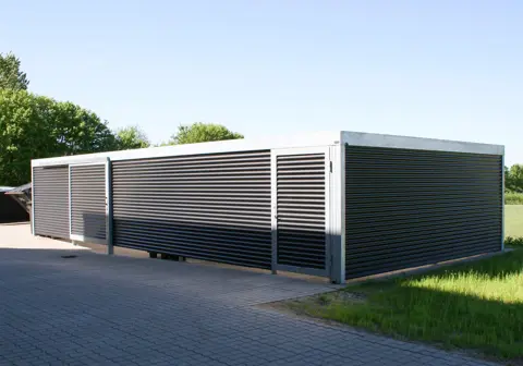UNA teknikrum med skydedør og forlængelse til containergård. Beklædt med sinusplader.