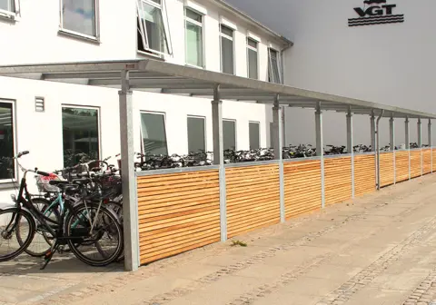 Stor PLAN overdækket cykelparkering med afskærmning i træ