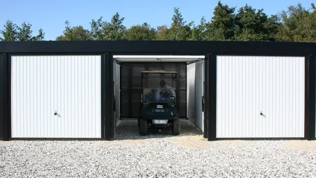 Stort garageanlæg med vippeporte til golfbiler. Model KUBIC